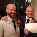 Male grooms same sex marriage holding marriage certificate